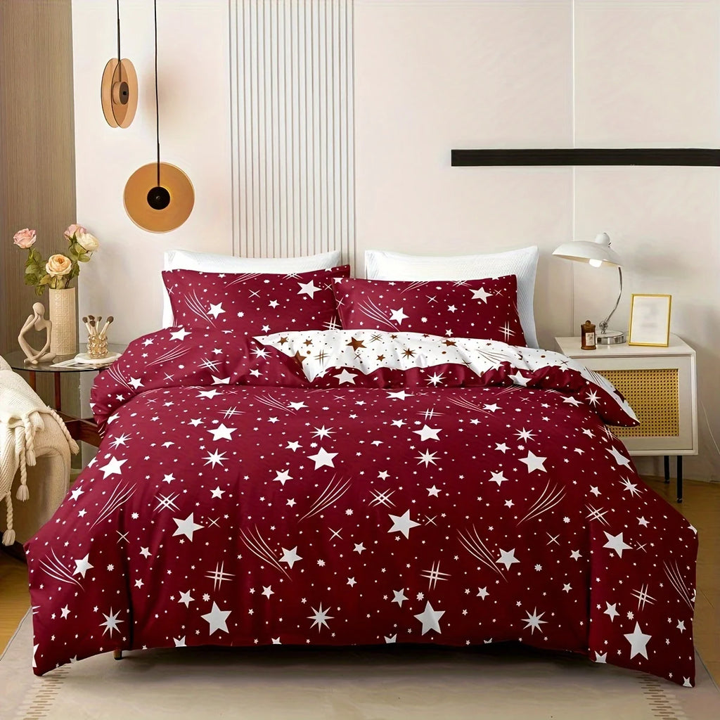 Red star-patterned bedding set in a bedroom with a nightstand and lamp.