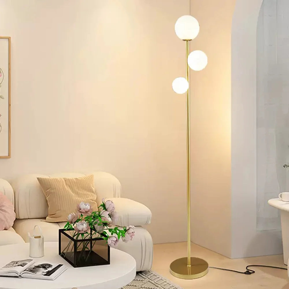 Modern floor lamp in a living room setting with a sofa and coffee table.