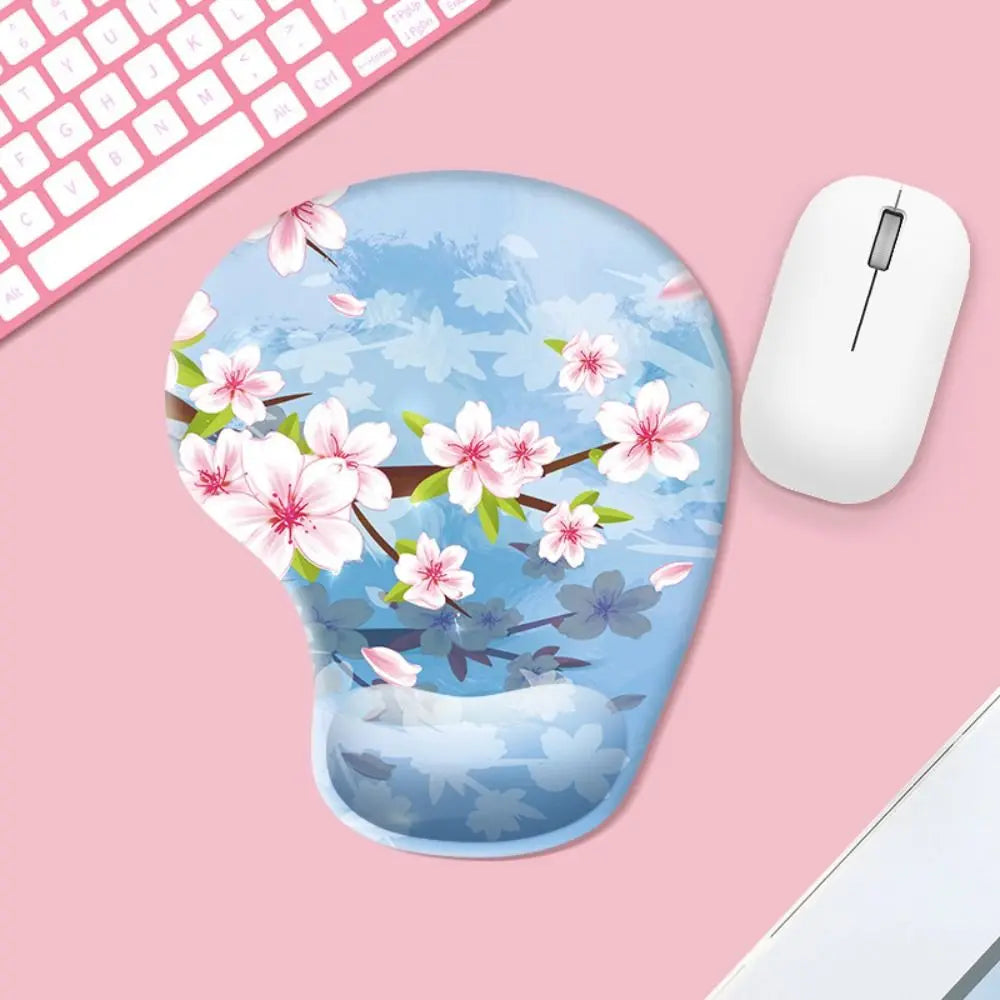 Mouse pad with cherry blossom design on a pink surface with a mouse and keyboard.