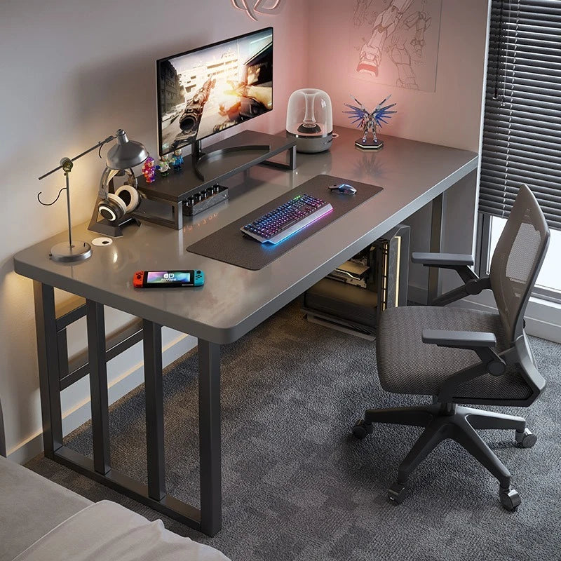 Modern gaming setup with desk, chair, and electronic devices in a room.