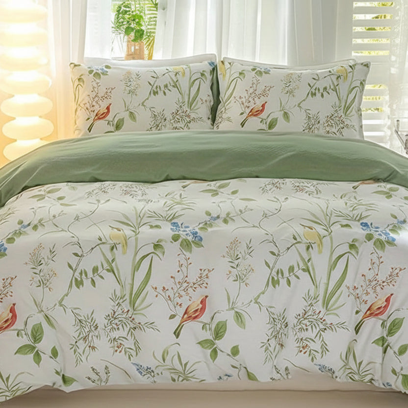Floral and bird print duvet cover set with soft green reverse on a styled bed