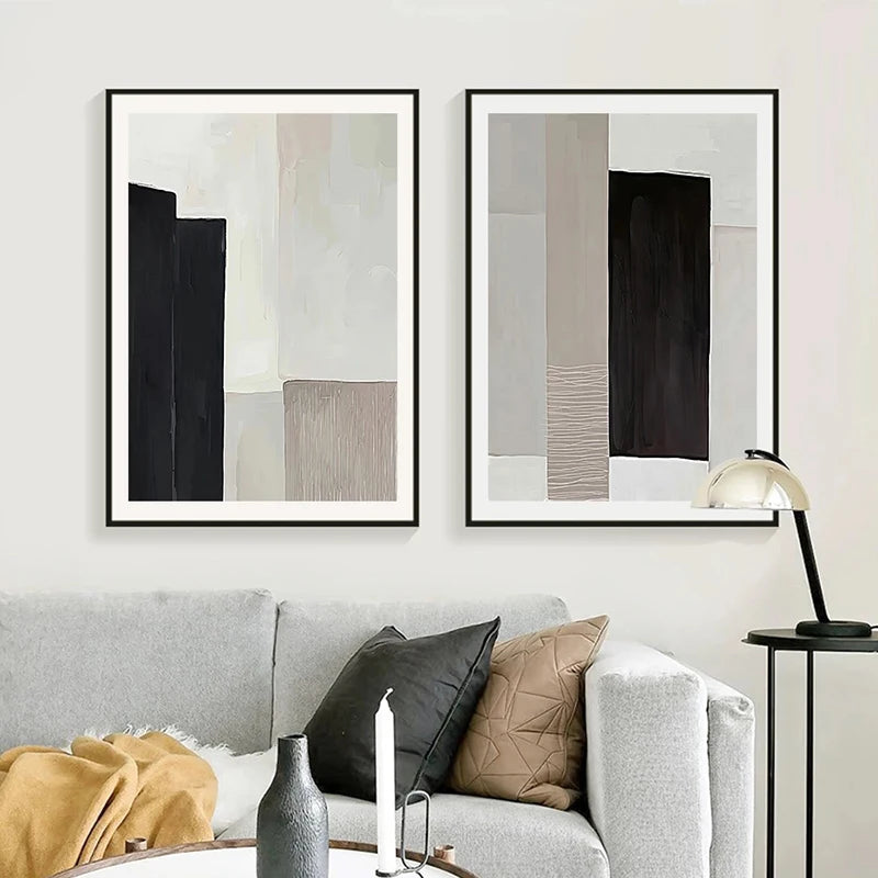 Two abstract art pieces on a wall above a sofa with decorative pillows and a lamp.