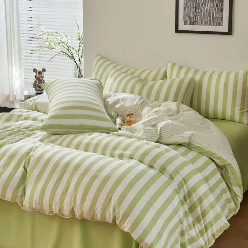 Sage green and white striped Polyester bedding set with duvet cover, flat sheet and pillowcases styled on a bed.