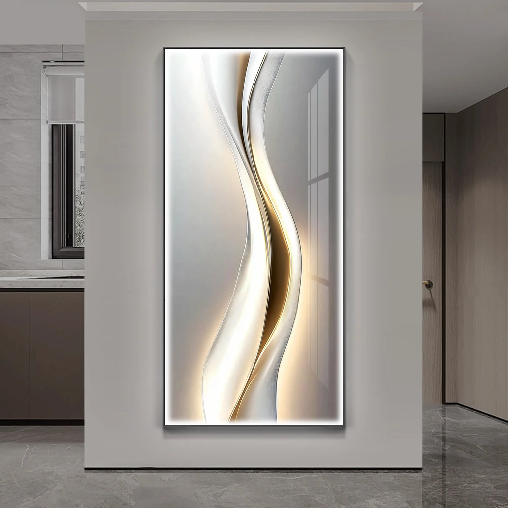 White and gold fluid wave LED wall art panel illuminated on a grey wall in a modern hallway