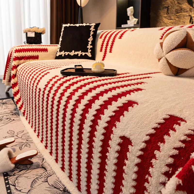 A plush quilted sofa cover with a modern red serrated stripe pattern on a cream background.