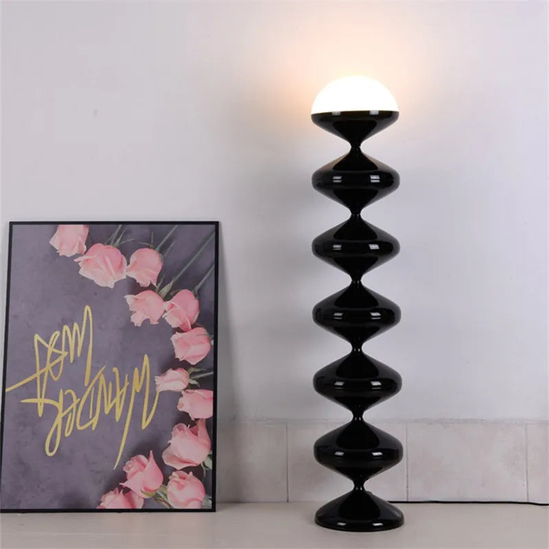 Black sculptural floor lamp with frosted dome shade