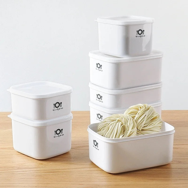 Set of white food storage containers with noodles on a wooden surface