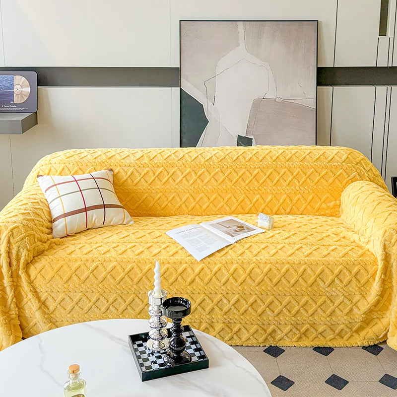 Yellow diamond-patterned sofa cover on a sofa with a decorative pillow and small table in a room.