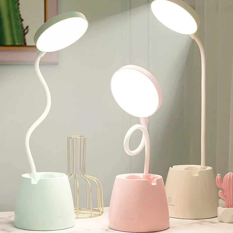 Three LED desk lamps in different colours on a light grey background