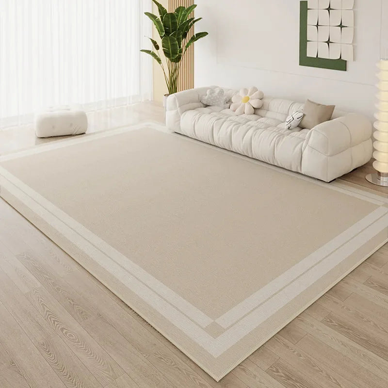Large cream area rug with simple tonal double line border in a bright minimalist living room with white cloud sofa