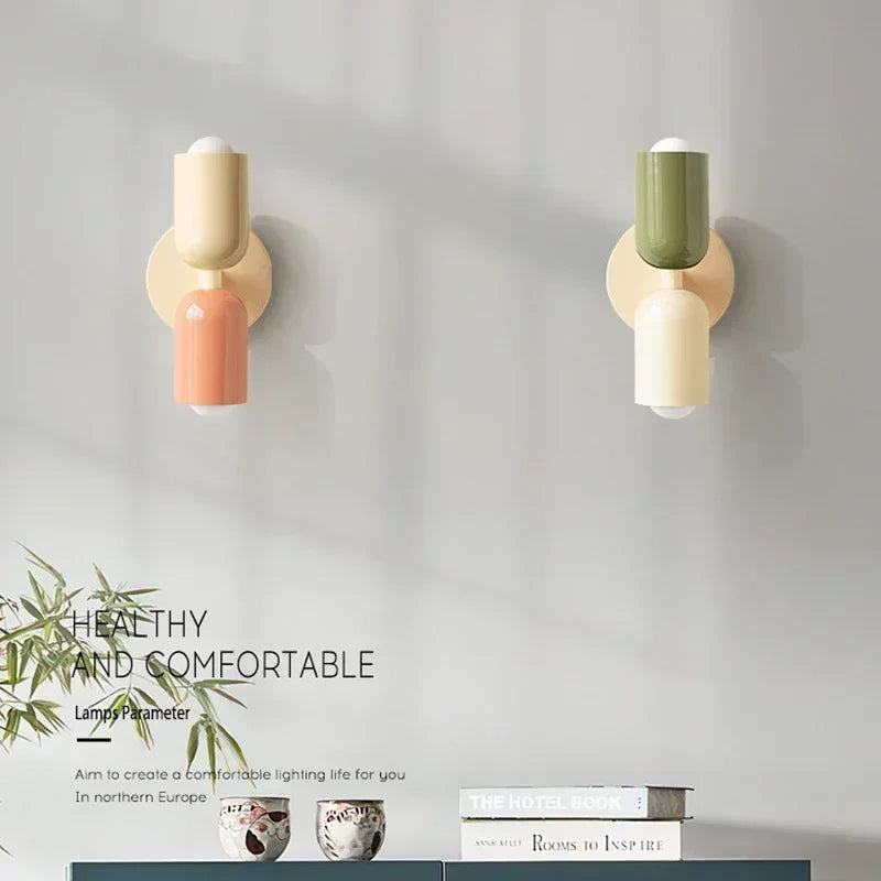 Two wall-mounted lamps with colorful bases on a gray wall, featuring text about healthy and comfortable lighting.