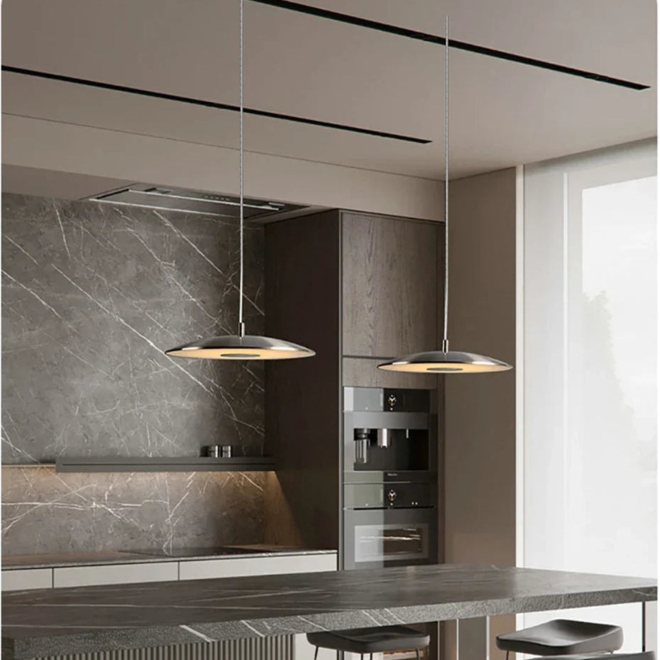 Modern kitchen with pendant lights, marble backsplash, and stainless steel appliances.