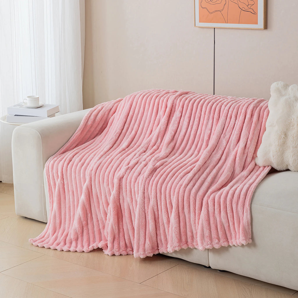 Pink blanket draped over a sofa in a living room setting