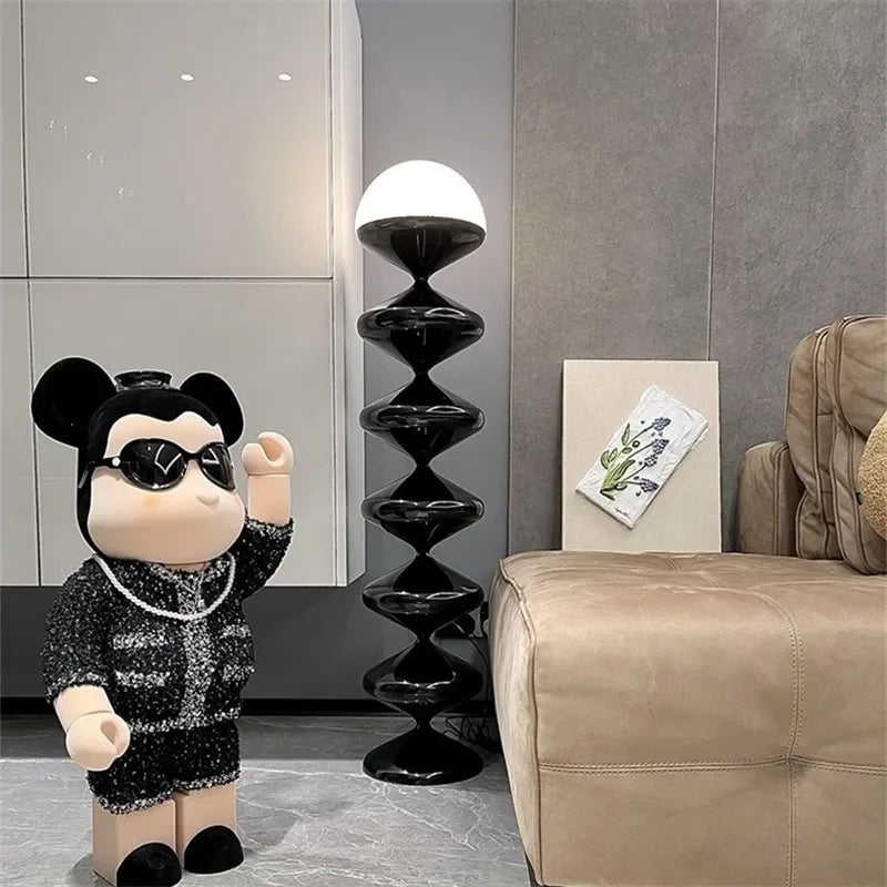 Black sculptural floor lamp with frosted dome shade