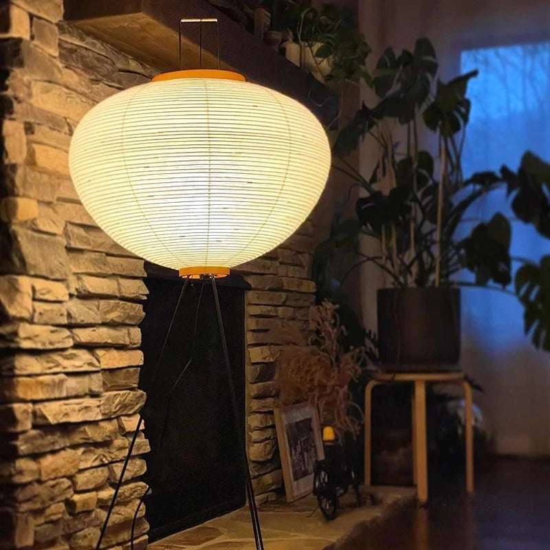 A Japanese floor light fixture near a stone wall and plants