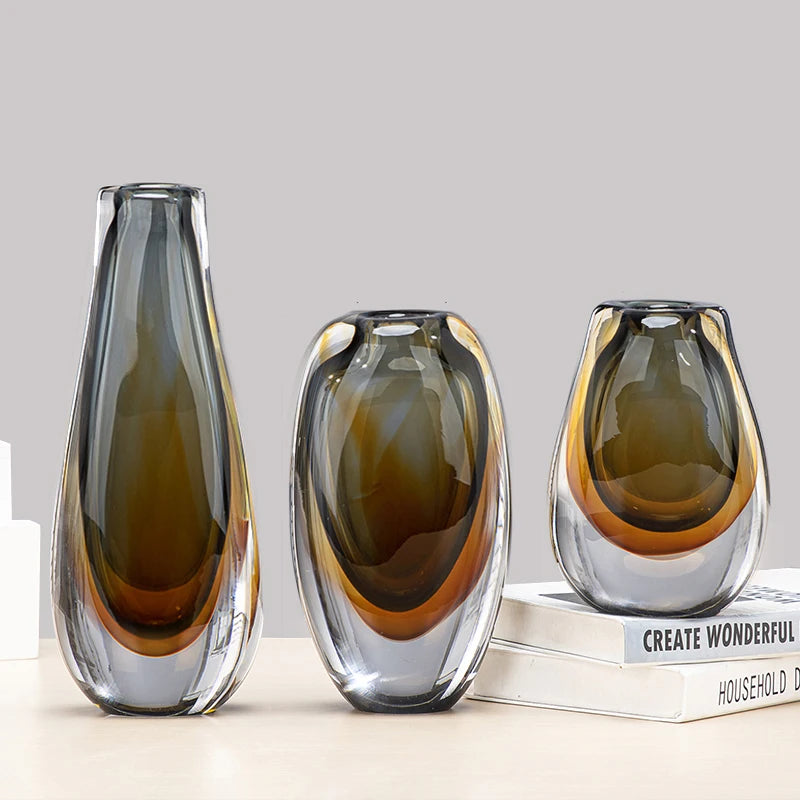 Three amber gradient glass vases styled together on books