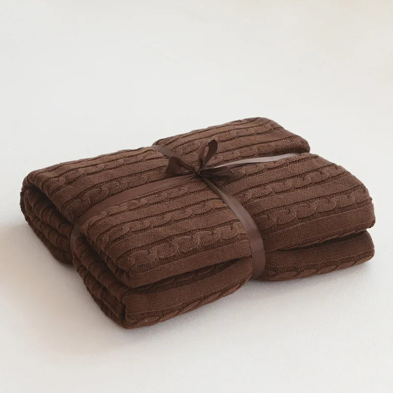 Folded brown textured blanket on a white background