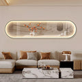 Oval-shaped LED wall art displaying a minimalist scene of a branch with orange persimmons and small white birds against a warm beige background, mounted above a contemporary beige sofa.