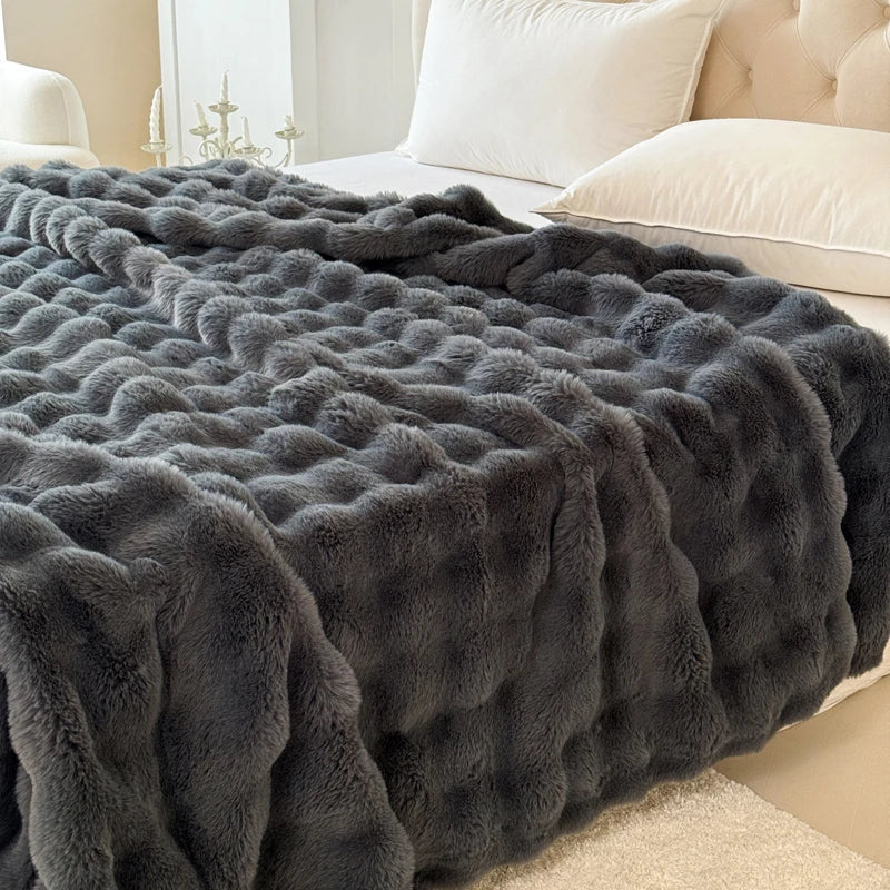 Grey textured blanket on a bed in a bedroom setting