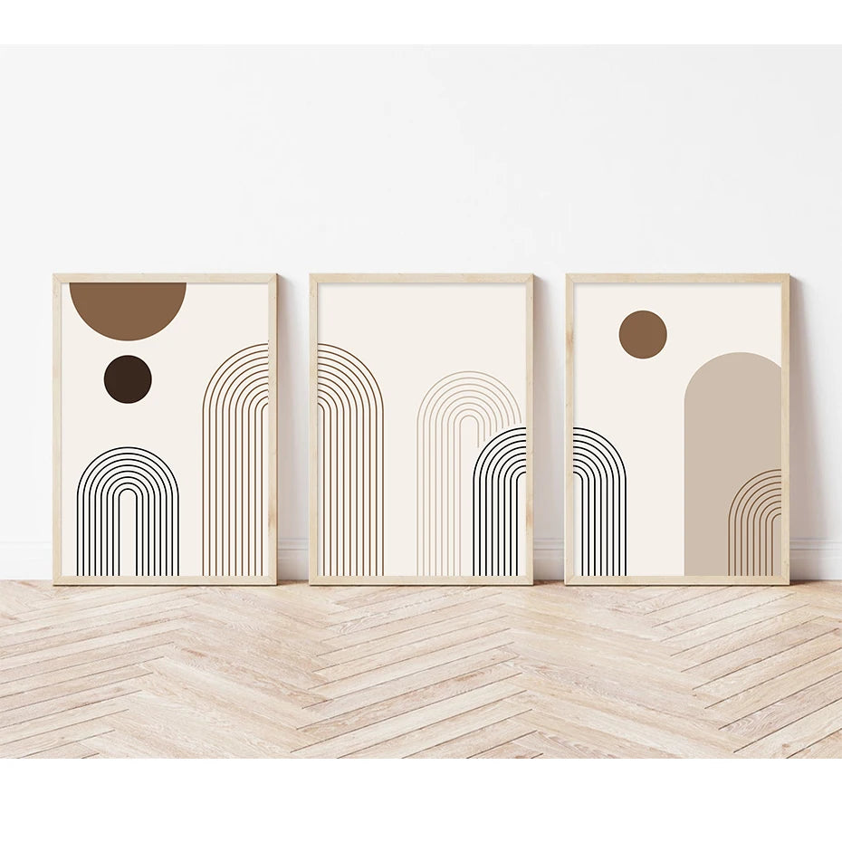 Three abstract art prints with geometric shapes on a wooden floor.