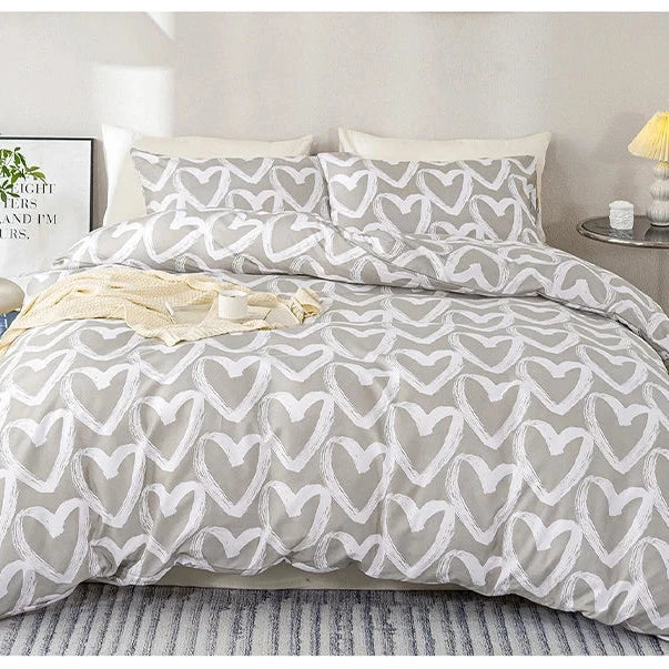 Gray and white heart-patterned comforter set on a bed in a bedroom setting.