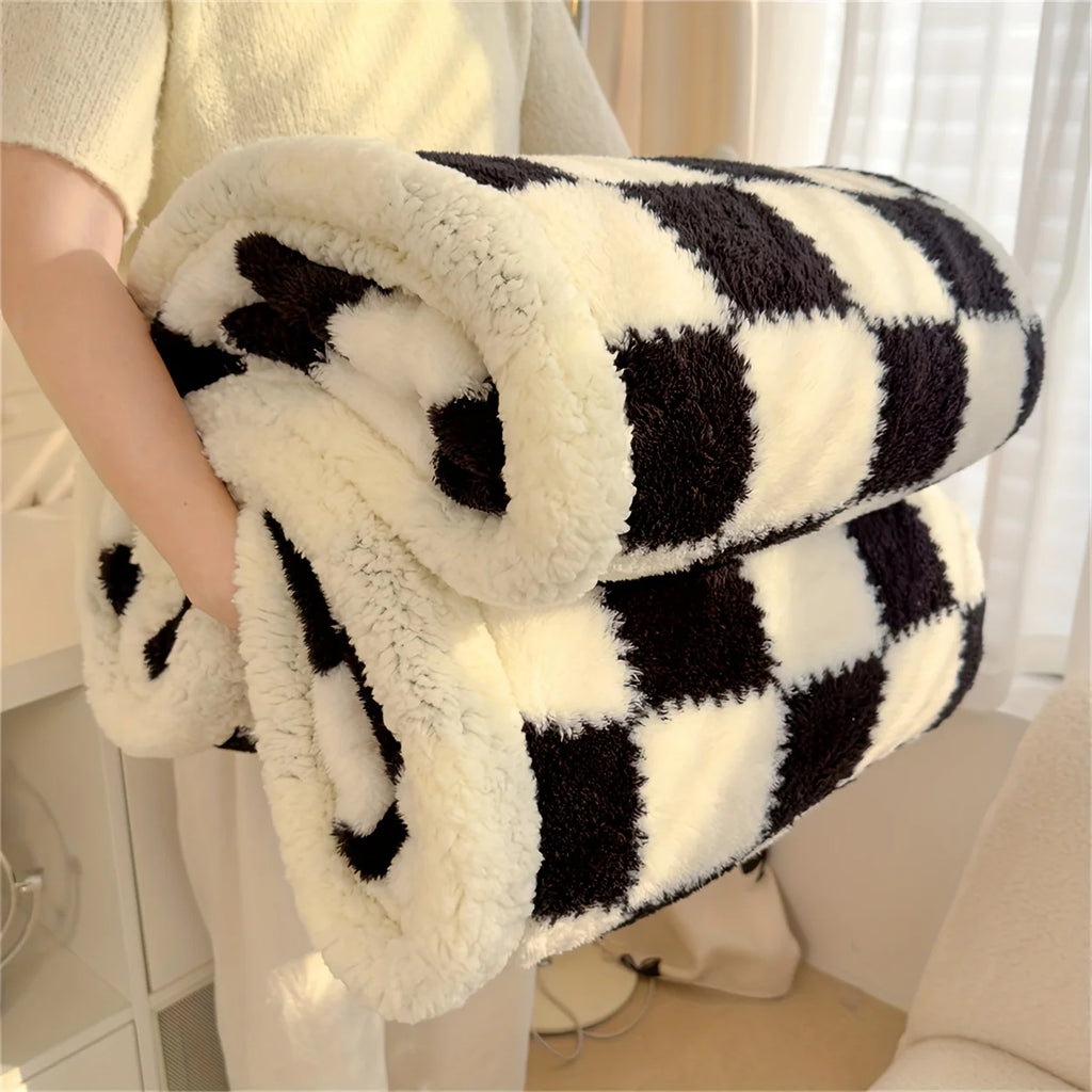 Black and white checkered blanket held by a person in a home setting