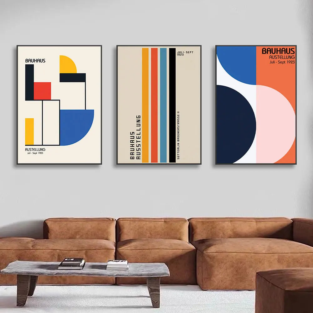 Three abstract art prints on a wall above a brown sofa.