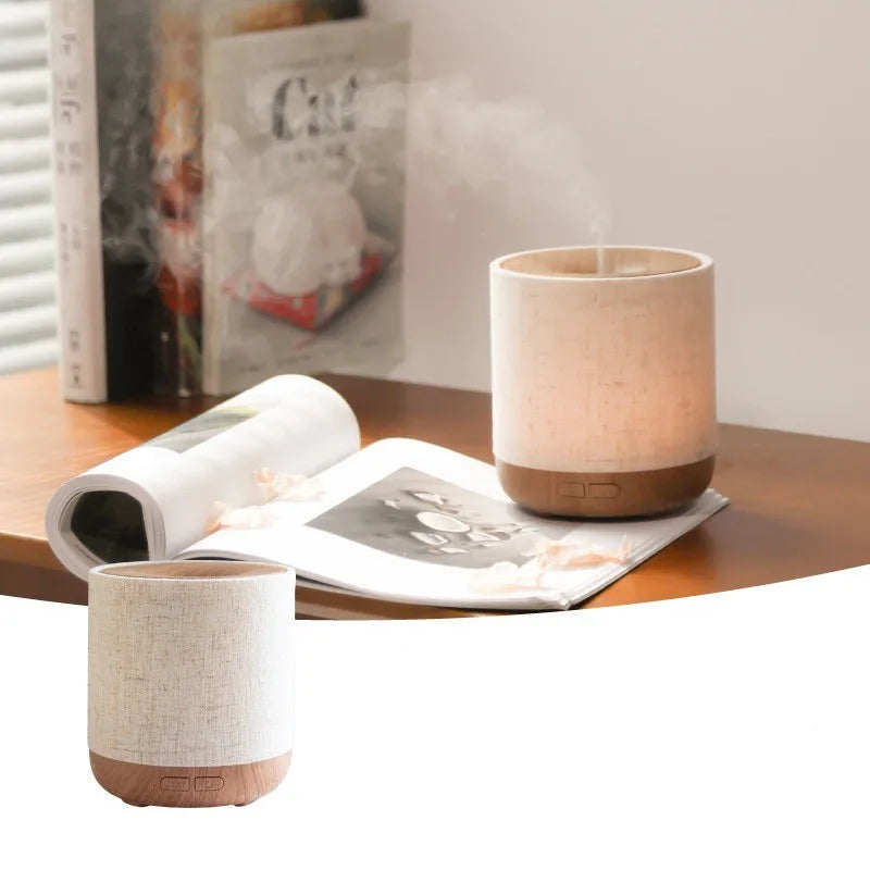 Two fabric aroma diffusers on a table with a magazine in the background