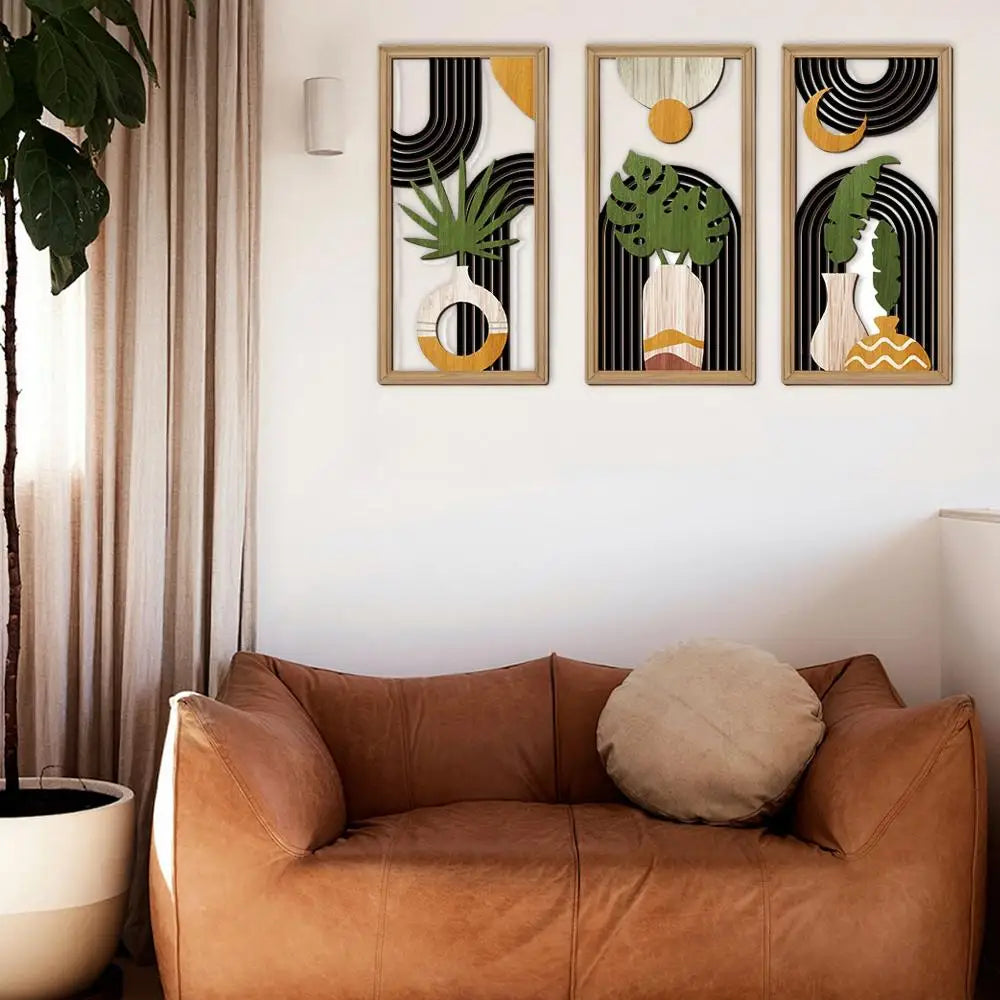 Three abstract art prints on a wall above a brown sofa with a beige pillow.