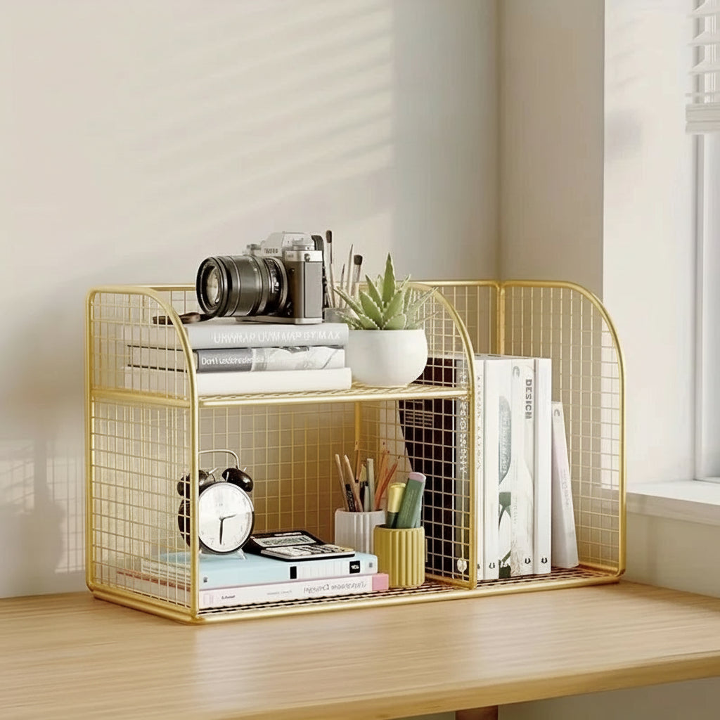 Gold wire desk organizer with books, a camera, and other items on a wooden surface.