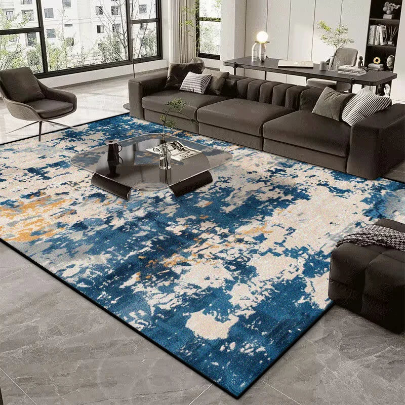 Living room with a blue and white abstract rug, gray sofa, and modern decor.