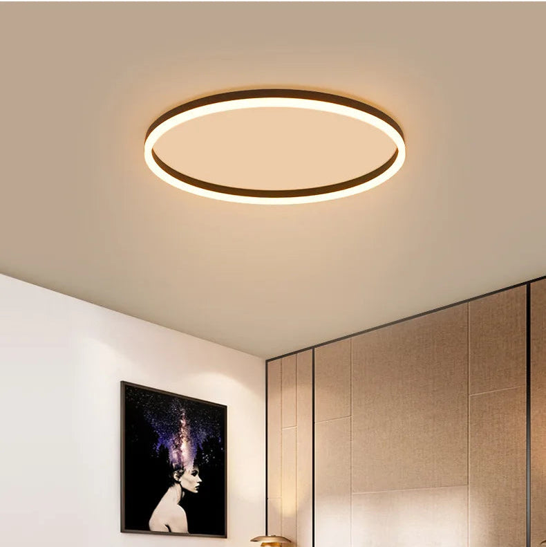 Black modern round LED ceiling light with warm circular glow and surface-mounted design.