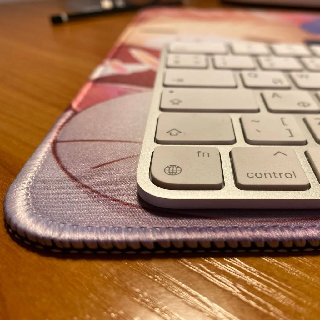 Small keyboard on a colorful mouse pad with a pen in the background