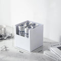 Box of Corona Extra beer cans on a marble surface with dimensions indicated.