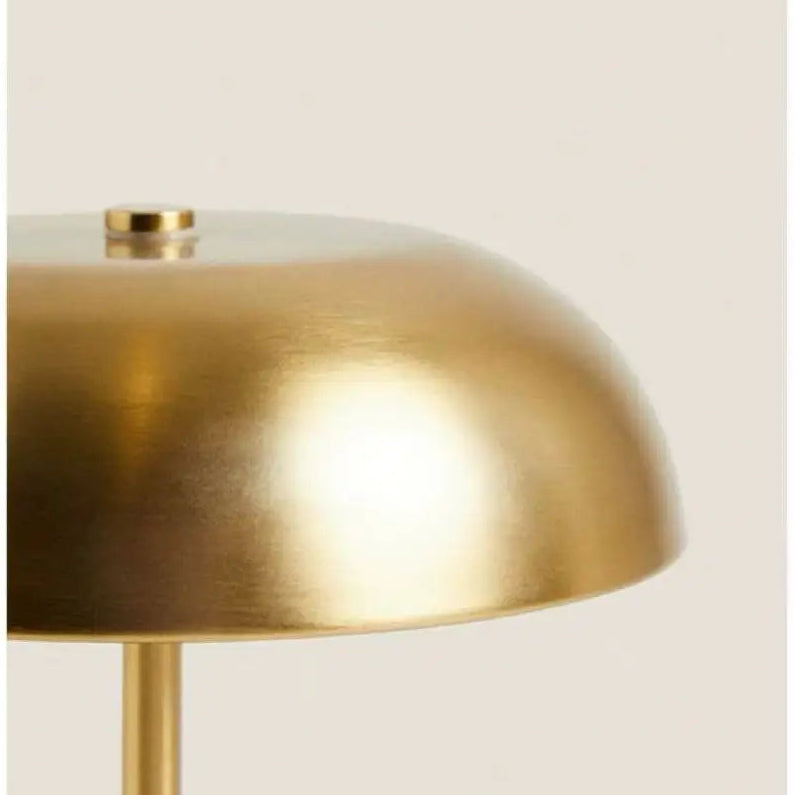 Close-up of a gold lampshade with a beige background