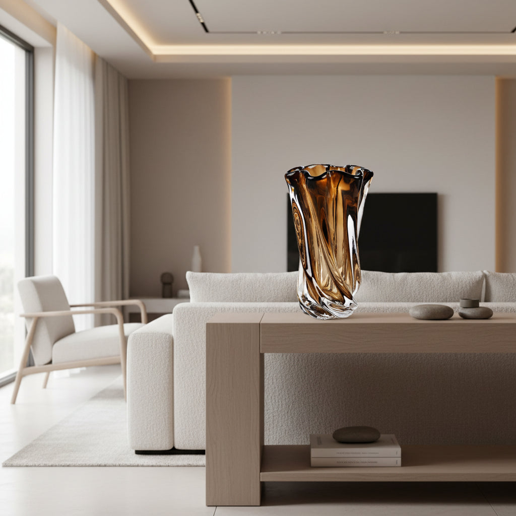 Brown and clear glass vase on a white surface with books and flowers in the background