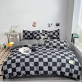 Black and grey checkerboard duvet cover set with matching pillowcases dressed on a double bed in a modern styled bedroom