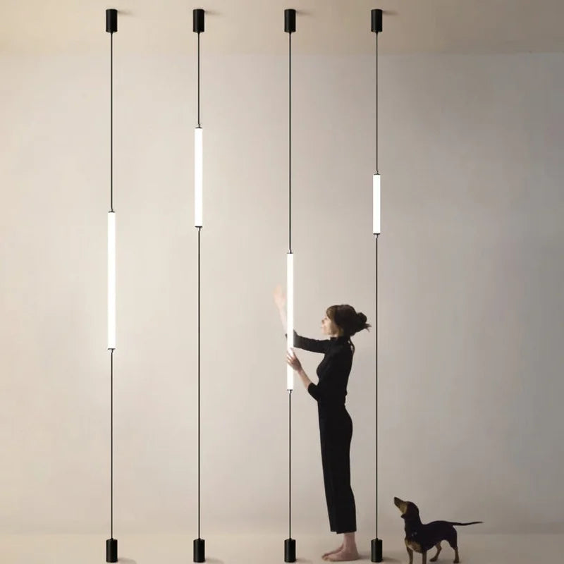 A woman adjusting  lights with a dog in a minimalistic room