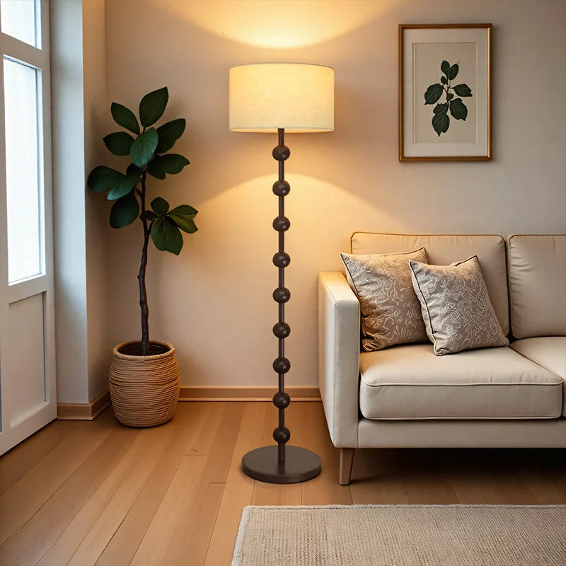 Living room with a beige sofa, floor lamp, and plant.