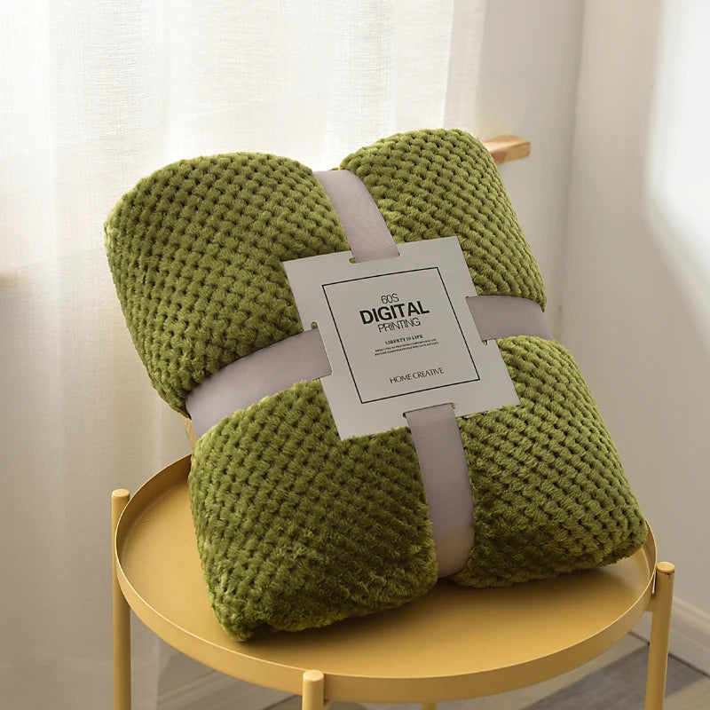 Green knitted blanket on a yellow stool with a tag labeled 'Digital Perfection'.