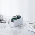 White can holder with two cans on a white surface with measurement details.