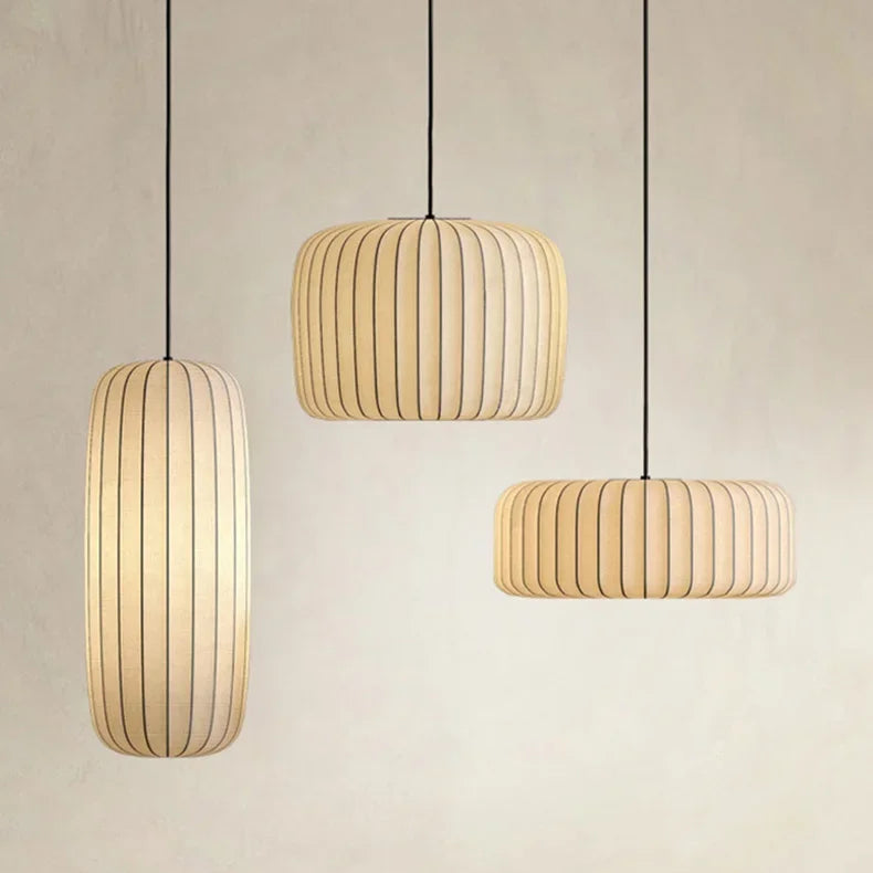 Three pendant lights hanging above a dining table with a neutral background