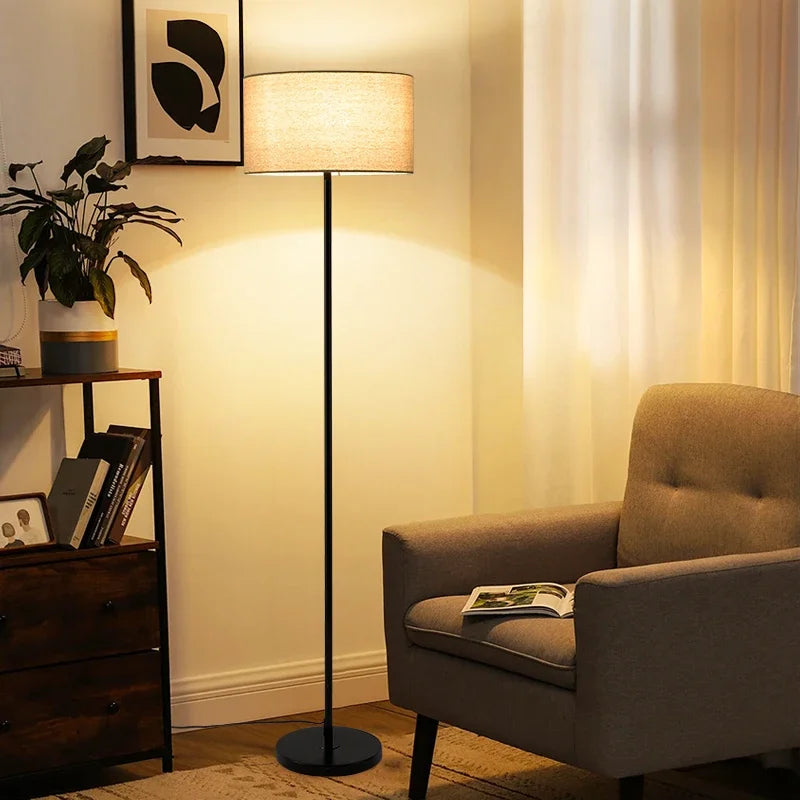 Full view of the minimalist Black Floor Lamp with a lit beige fabric shade.