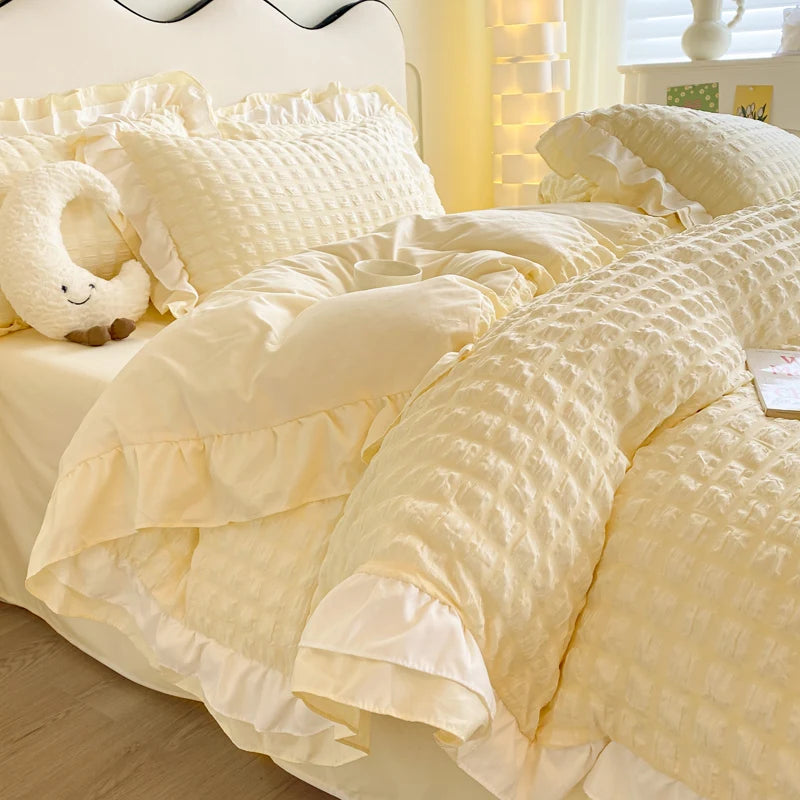 Yellow textured comforter on a bed with pillows and a plush toy.