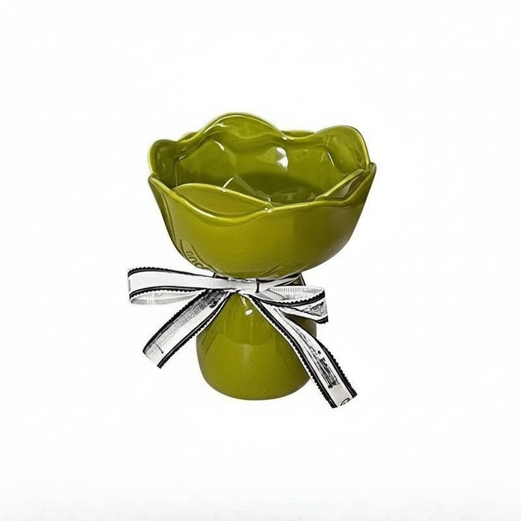 Green decorative item with a silver bow on a white background