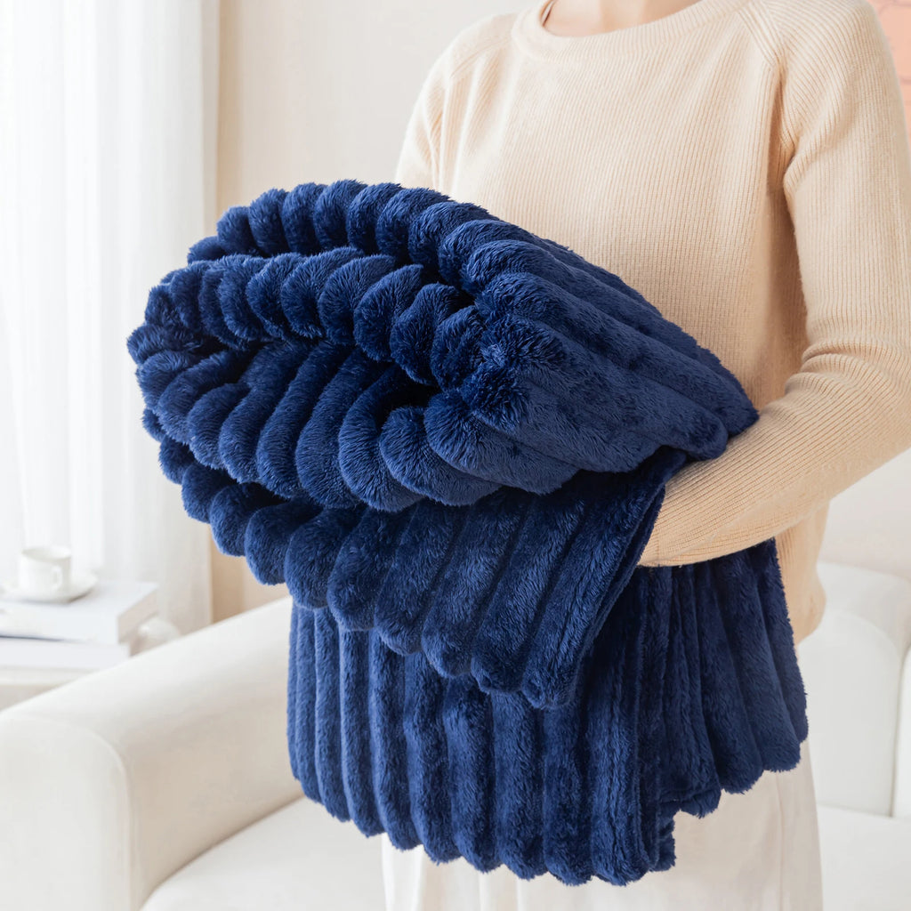 Person holding a blue fluffy blanket in a bright room