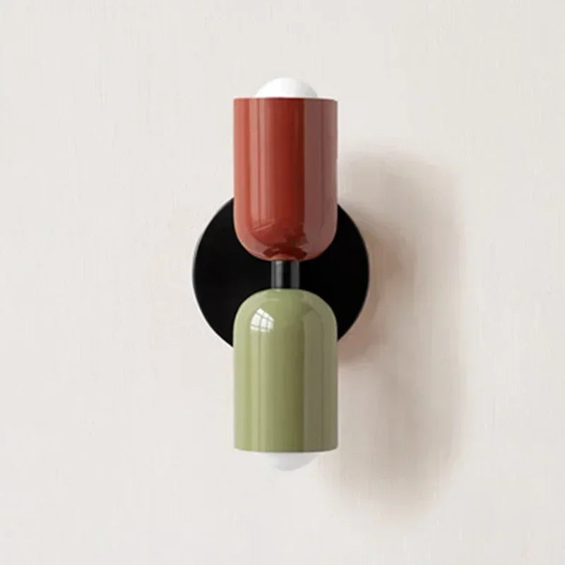 Red and green two-tone wall sconce on black backplate