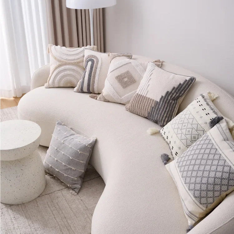 White sectional sofa with patterned cushions in a living room setting.