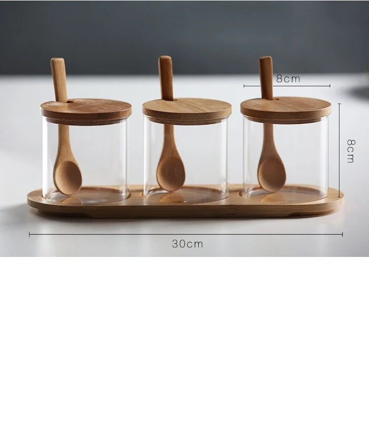 Three glass jars with wooden lids and spoons on a wooden tray, with measurements indicated.