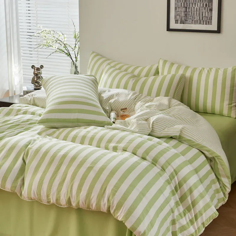 Sage green and white striped Polyester bedding set with duvet cover, flat sheet and pillowcases styled on a bed.